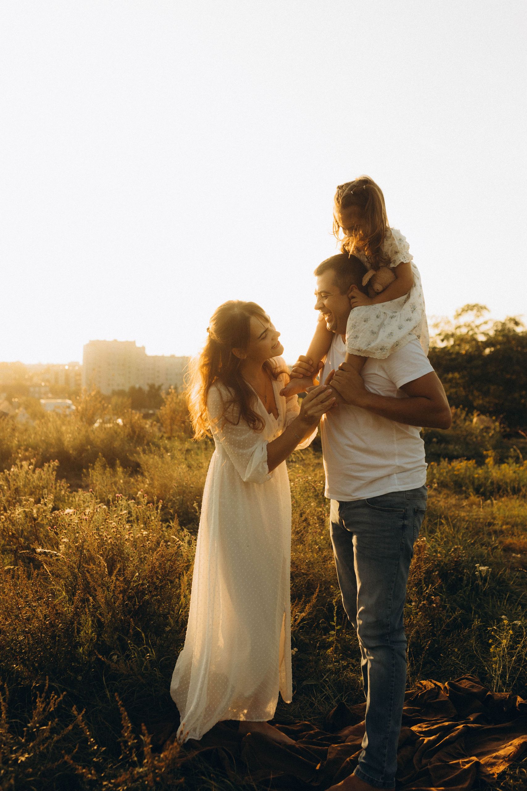 A family enjoys a beautiful sunset outdoors, capturing a moment of love and togetherness.